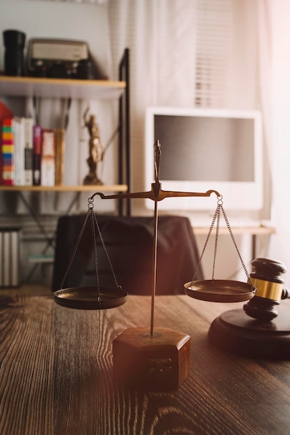 Foto conceito de justiça e direito juiz masculino em um tribunal com o martelo trabalhando com computador e óculos de teclado de encaixe na mesa na luz da manhã