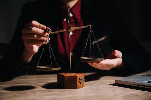 Conceito de justiça e direito Juiz masculino em um tribunal com o martelo trabalhando com computador e óculos de teclado de encaixe na mesa na luz da manhã