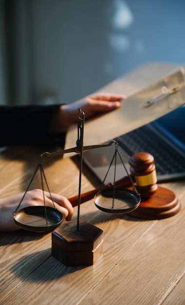 Foto conceito de justiça e direito juiz masculino em um tribunal com o martelo trabalhando com computador e óculos de teclado de encaixe na mesa na luz da manhã