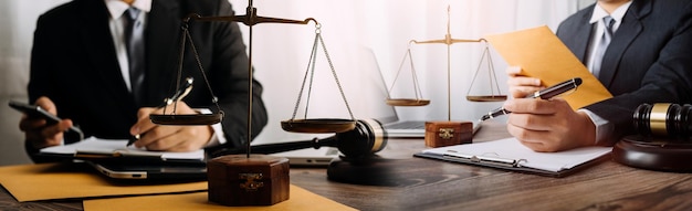 Conceito de justiça e direito Juiz masculino em um tribunal com o martelo trabalhando com computador e óculos de teclado de encaixe na mesa na luz da manhã