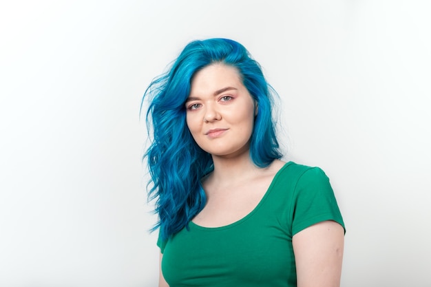 Conceito de juventude, estilo e moda - Uma jovem mulher bonita com cabelo azul está sorrindo sobre o branco