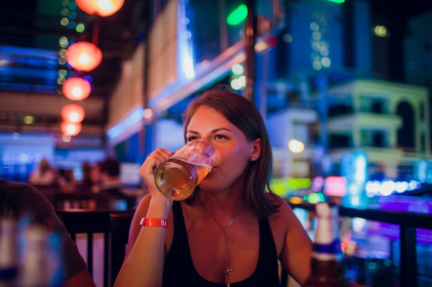 Conceito de lazer, alimentação, alimentos e bebidas, pessoas e feriados - amigos de sorriso jantando e bebendo cerveja no restaurante ou pub