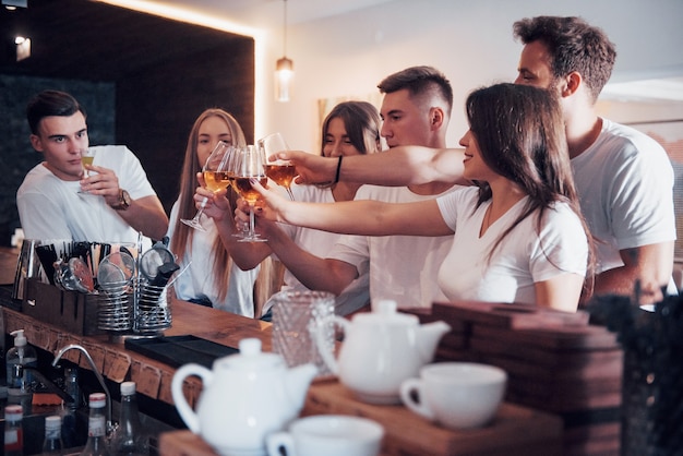 Conceito de lazer e comunicação. grupo de amigos felizes e sorridentes, desfrutando de bebidas e conversando no bar ou pub.