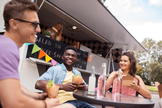 Foto conceito de lazer e pessoas amigos felizes com bebidas comendo em food truck