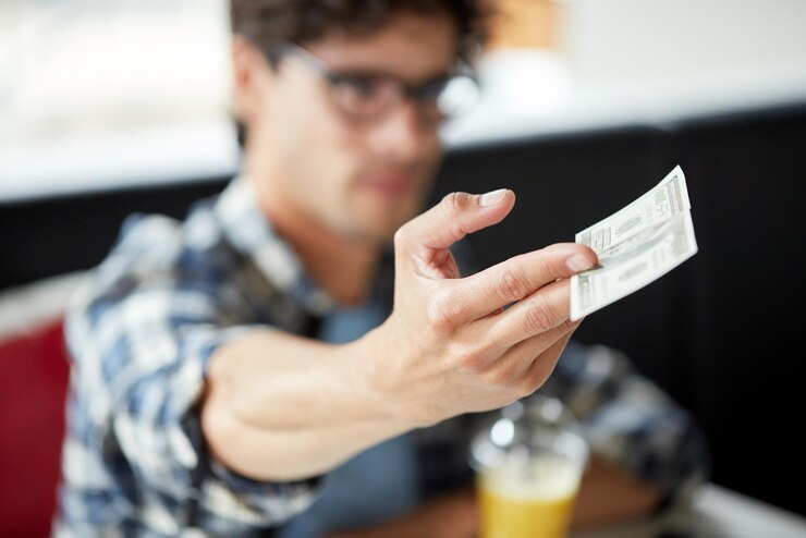 Foto conceito de lazer, pessoas, pagamento e finanças - homem com dinheiro a pagar num café