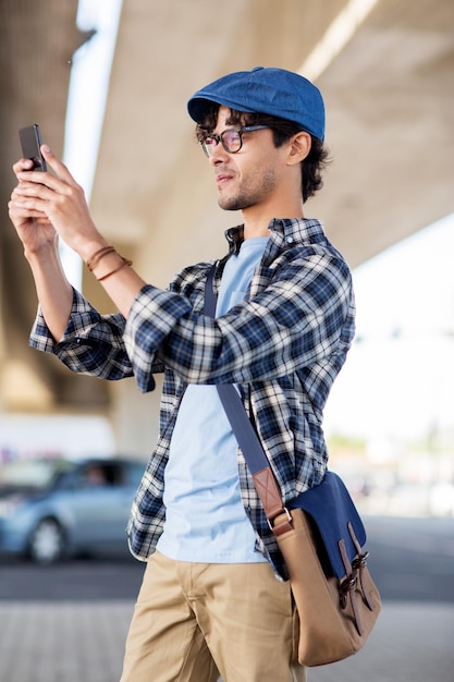 conceito de lazer, tecnologia e pessoas - homem hipster tirando foto de selfie por smartphone na rua