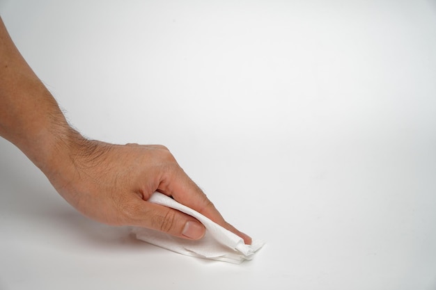 Foto conceito de limpeza de mesaa mão do homem está usando um papel de tecido para limpar a mesa branca