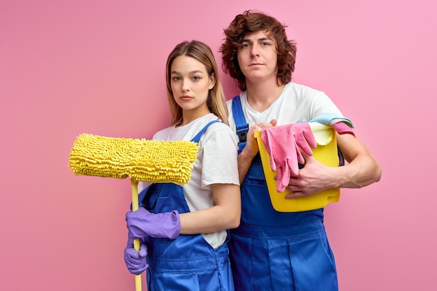 Conceito de limpeza. Marido e mulher confiantes com produtos de limpeza em mãos começam a limpar a casa