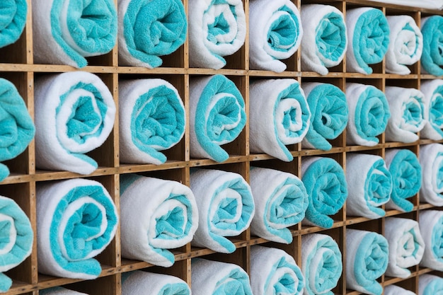 Foto conceito de luxo e higiene - close-up da prateleira com toalhas de banho enroladas no spa do hotel