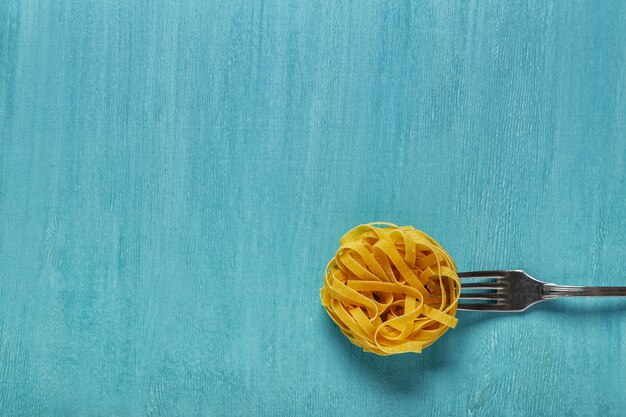 Foto conceito de macarrão alimentar em uma vista superior de fundo azul