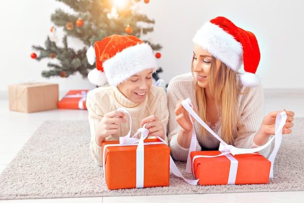 Conceito de mãe solteira e feriados - retrato de mãe comemorando o natal em casa na véspera de natal.