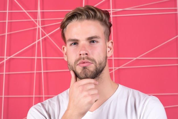 Conceito de masculinidade Homem com cerdas no rosto pensativo fundo rosa Cara barbudo e atraente com penteado Homem com barba ou cara não barbeado parece bonito e bem arrumado