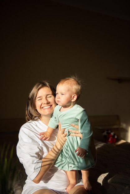 Conceito de maternidade e as pessoas familiares - mãe feliz e sorridente e bebê em casa. Luz de tendência