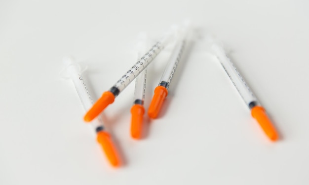 conceito de medicina, diabetes e cuidados de saúde - close-up de seringas de insulina na mesa