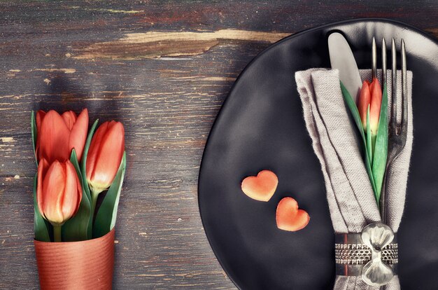 Conceito de menu primavera com tulipas frescas e decoração de coração em madeira escura