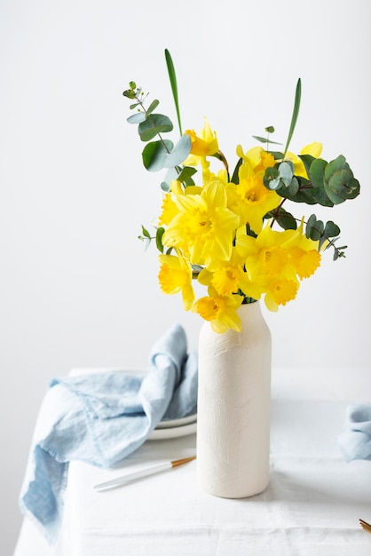 Conceito de mesa de Páscoa românica com flores e imagem de foco seletivo de toalha de mesa branca