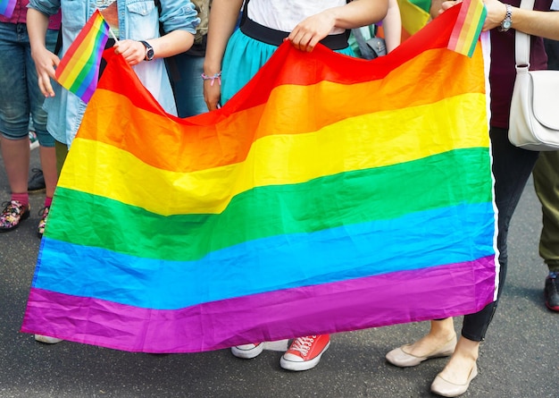 Conceito de minoria sexual Pessoas segurando a bandeira do arco-íris gay ao ar livre