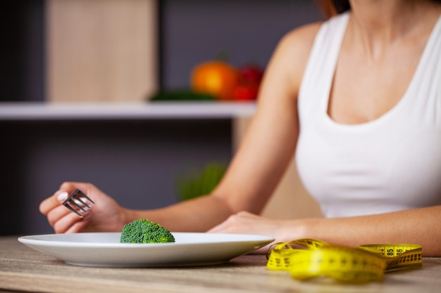 Foto conceito de mulher com excesso de peso, comendo dieta de brócolis.