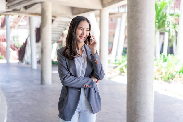 Conceito de mulher trabalhadora, uma mulher que trabalha com uma carinha sorridente, falando ao telefone com seu parceiro de negócios.