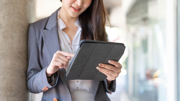 Conceito de mulher trabalhando, uma jovem mulher de negócios trabalhando online em seu negócio com os dispositivos de alça, tablet, fora do local de trabalho.