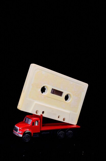Foto conceito de música caminhão vermelho e fita de áudio em um fundo preto