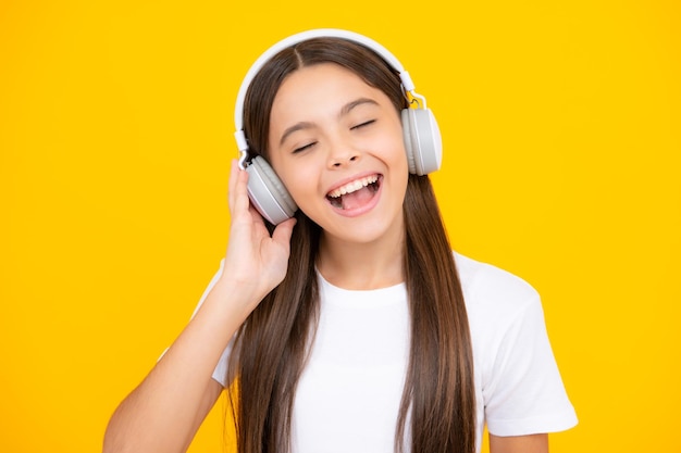 Conceito de música infantil Menina adolescente dança no ritmo da melodia ouve música em fones de ouvido Criança ouvindo música através de fones de ouvido