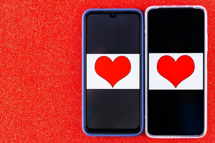 Foto conceito de namoro online. metades do coração nas duas telas dos smartphones. conceito de dia dos namorados