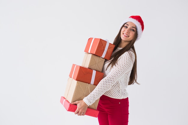 Conceito de Natal e feriados - mulher com chapéu de Papai Noel com muitos presentes no espaço em branco com espaço de cópia