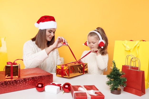 Conceito de natal. mãe com a garota de férias. desempacotando presentes juntos.