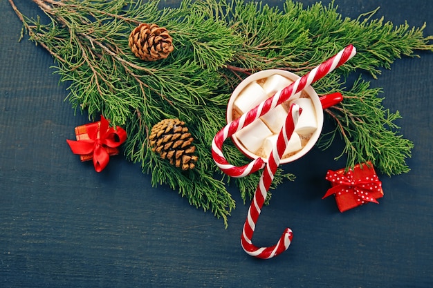 Conceito de natal. xícara de chocolate quente com marshmallow e enfeites na mesa de madeira