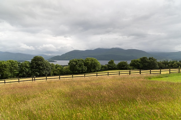 conceito de natureza e paisagem - vista para o lago ou rio, colinas e terras agrícolas em connemara, na irlanda