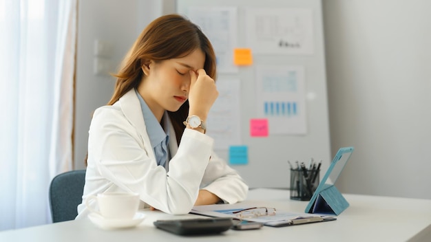 Conceito de negócio bem sucedido Mulher de negócios sentindo dor de cabeça depois de trabalhar duro sobre o novo projeto