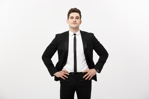 Conceito de negócio: homem bonito, sorriso feliz, rapaz bonito, terno inteligente, posando sobre fundo cinza isolado.