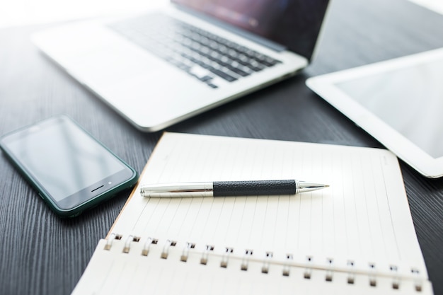 Conceito de negócio, no local de trabalho do escritório com o laptop na mesa de madeira contra as janelas