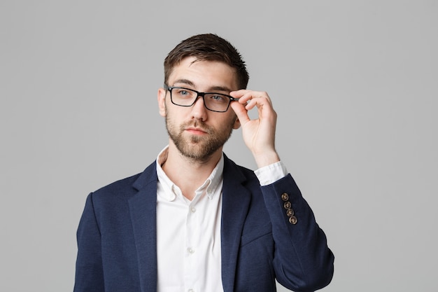 Conceito de negócio - Retrato de um empresário bonito em terno com óculos de pensamento sério com expressão facial estressante. Fundo branco isolado. Espaço de cópia.