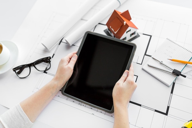 conceito de negócios, arquitetura, construção, construção e pessoas - close-up da mão do arquiteto com planta de casa viva e computador tablet pc