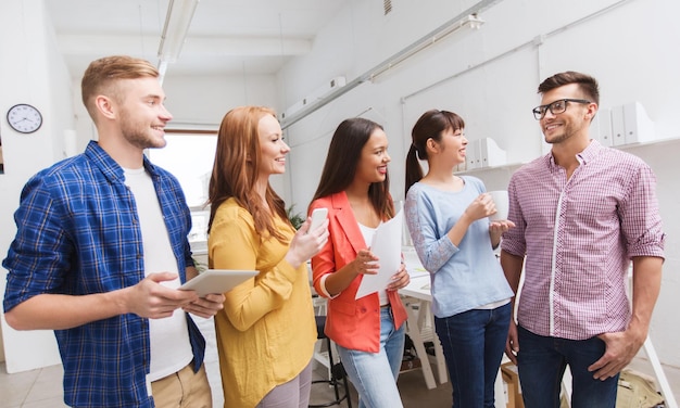 conceito de negócios, comunicação, inicialização e pessoas - feliz equipe criativa internacional ou estudantes no intervalo para café conversando no escritório