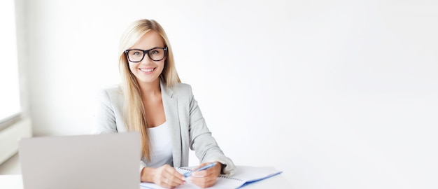 Conceito de negócios e educação - foto interna de uma mulher sorridente com documentos e caneta