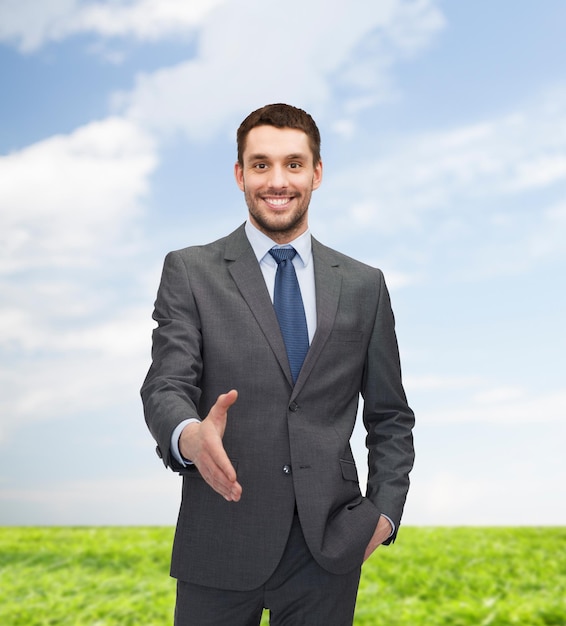 conceito de negócios e escritório - empresário bonito com mão aberta pronta para aperto de mão