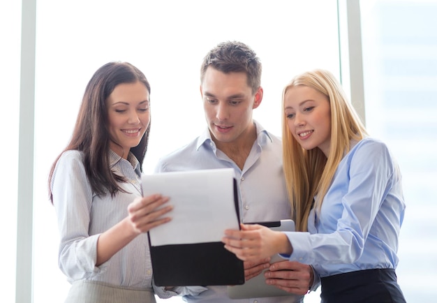 Conceito de negócios e escritório - equipe de negócios sorridente olhando para a área de transferência