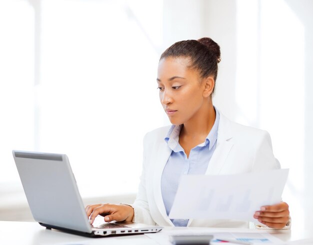 conceito de negócios e impostos - empresária africana trabalhando com computador no escritório