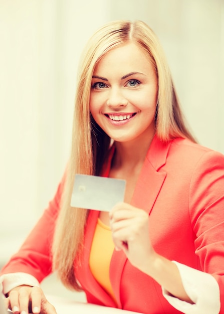 conceito de negócios e internet - empresária sorridente com laptop usando cartão de crédito