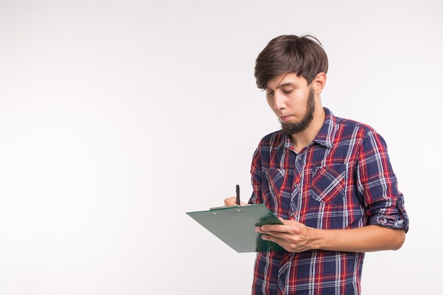 Conceito de negócios e planejamento - homem bonito e sorridente com prancheta no fundo branco com espaço de cópia