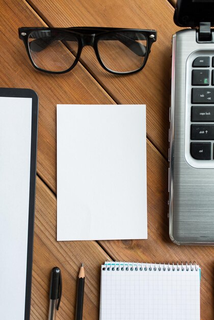 Foto conceito de negócios e tecnologia - close-up de papel em branco e material de escritório na mesa de madeira