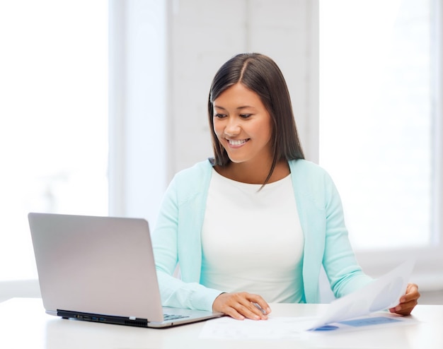 conceito de negócios, educação e tecnologia - mulher de negócios asiática ou estudante com laptop e documentos no escritório