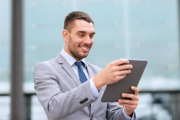 conceito de negócios, educação, tecnologia e pessoas - empresário sorridente trabalhando com computador tablet pc na rua da cidade