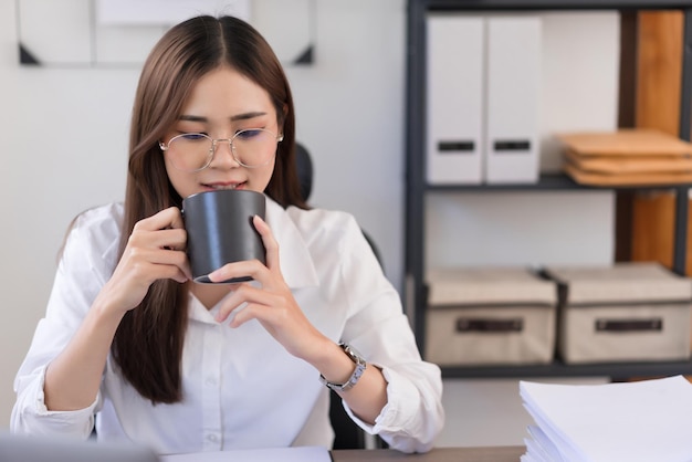 Conceito de negócios Empresária está bebendo café antes de começar a trabalhar de manhã no escritório moderno