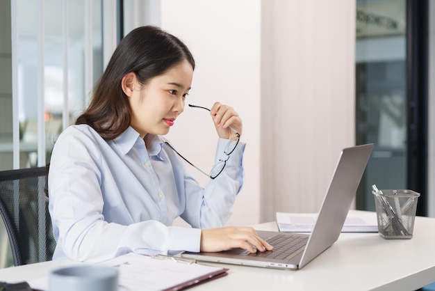 Conceito de negócios Empresária pesquisando e verificando dados de marketing no laptop no escritório