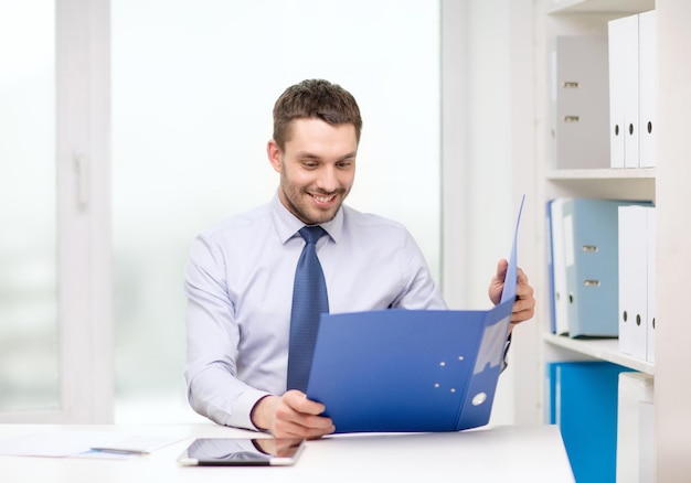 conceito de negócios, escritório e tecnologia - empresário sorridente com pasta e computador tablet pc no escritório