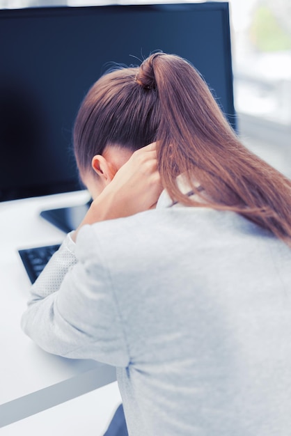 conceito de negócios, escritório, escola e educação - empresária estressada com computador no trabalho